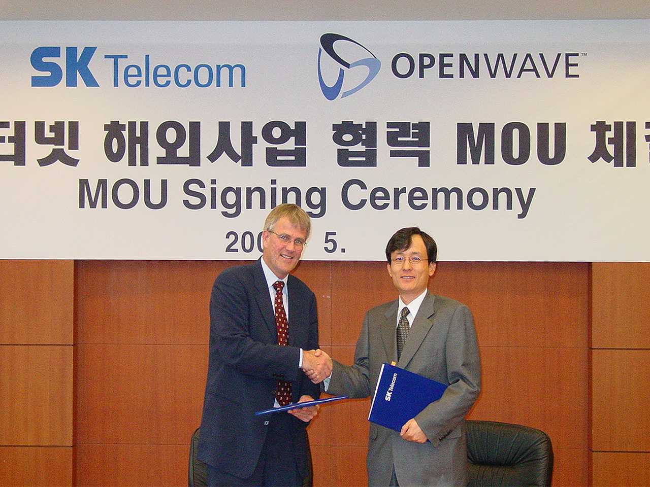 Photo shows Hyeon Oh Yoo, managing director of SK Telecom shaking hands with Peter Hogeuning , vice-president of Openwaves?s Asia-Pacific Region Branch Office, just after they signed the MOU